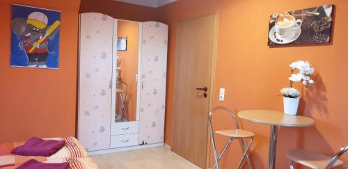 a room with orange walls and a table and a door at Gasthaus Pavillon in Dresden
