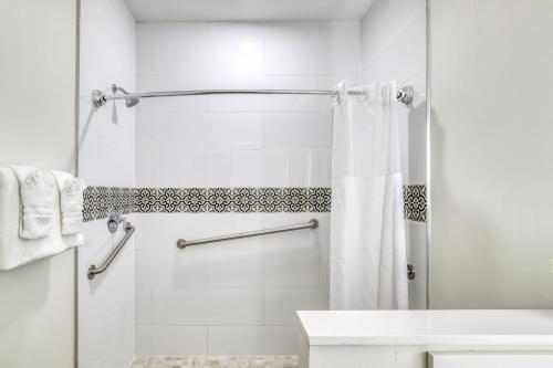 a white bathroom with a shower and a sink at Villa 1565 - Saint Augustine in Saint Augustine
