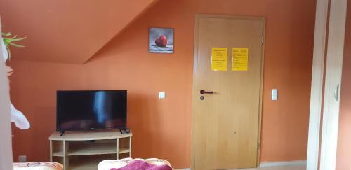 a room with a door and a tv and a wall at Gasthaus Pavillon in Dresden
