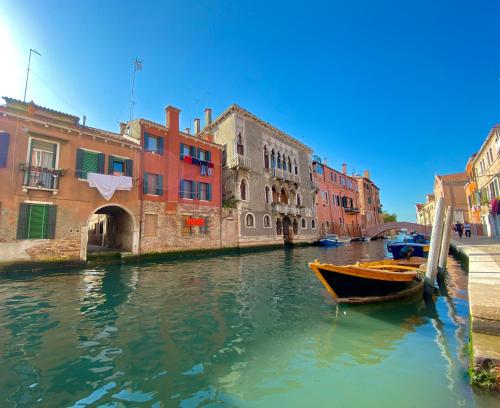 a boat is docked in a canal with buildings at CA CAMMELLO private terrace and canal view in Venice