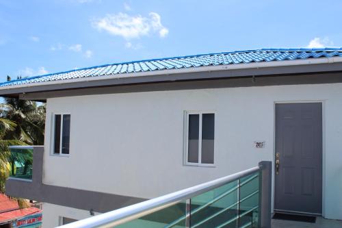 a white building with a door and a balcony at Barefoot Caye Caulker Hotel in Caye Caulker