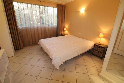 une chambre avec un lit blanc et une fenêtre dans l'établissement 2, 3 and 4 bedroom sea view Forville Apartments 5 mins from the Palais, à Cannes