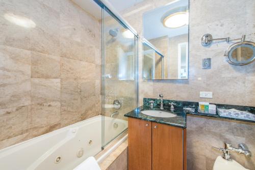 a bathroom with a tub and a sink and a shower at Lombardy Hotel in New York