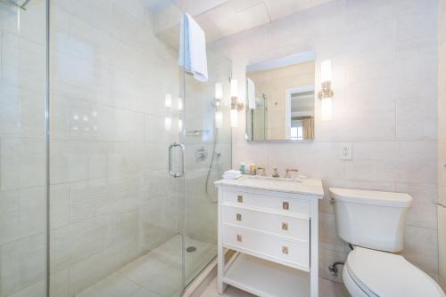 a white bathroom with a shower and a toilet at Lombardy Hotel in New York