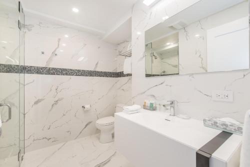 a white bathroom with a sink and a toilet at Lombardy Hotel in New York