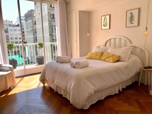1 dormitorio con cama con almohadas y ventana grande en GRAN DEPARTAMENTO! Cerca de San Telmo y Obelisco en Buenos Aires
