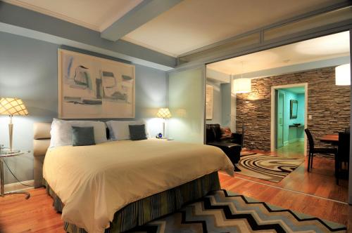 a bedroom with a large bed and a living room at Lombardy Hotel in New York