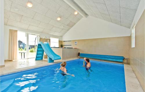 Bøtø ByにあるStunning Home In Idestrup With 7 Bedrooms, Wifi And Indoor Swimming Poolのスライダー付きスイミングプールの女の子2人