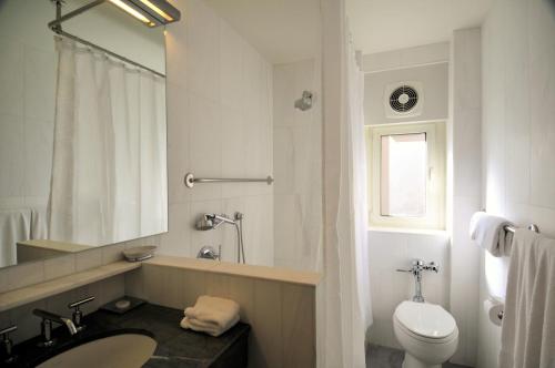 a white bathroom with a sink and a toilet at Lombardy Hotel in New York