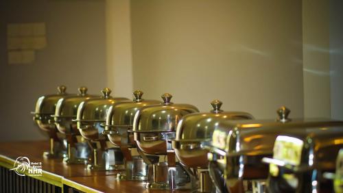 a row of copper pots sitting on top of a table at National Holiday Resort in Mahiyangana