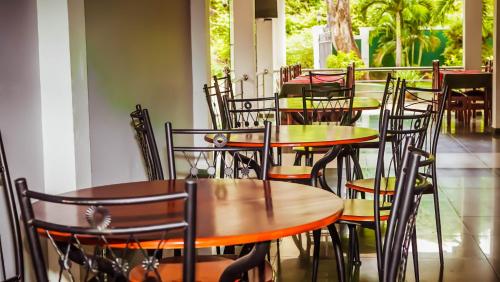 una fila de mesas y sillas en un restaurante en National Holiday Resort, en Mahiyangana