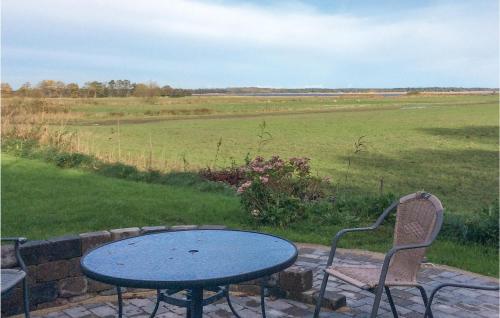 a table and two chairs and a table and a field at Three-Bedroom Holiday Home In Orsted in Udbyhøj