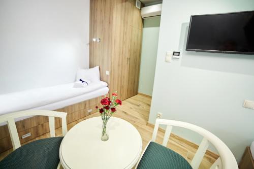 a small room with a white table with flowers on it at Ośrodek Ukazia in Orzechowo