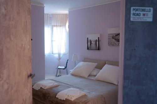a bedroom with a bed with white walls and a window at Residence Millecento in Cesenatico