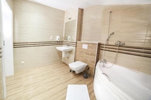 a bathroom with a toilet and a tub and a sink at Ośrodek Ukazia in Orzechowo