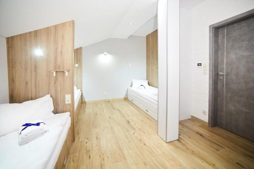 a bedroom with white walls and a wooden floor at Ośrodek Ukazia in Orzechowo
