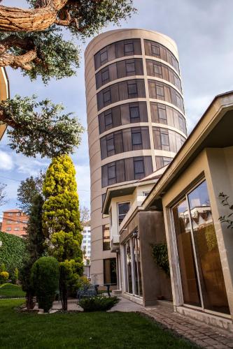 a tall building with a house in front of it at Hotel Boutique Rosario Sur in La Paz