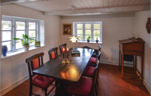 a dining room with a wooden table and chairs at Three-Bedroom Holiday Home In Orsted in Udbyhøj