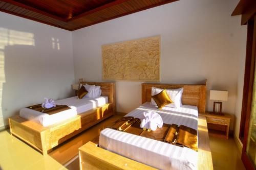 a hotel room with two beds and a table at Villa Danu Kintamani in Kintamani