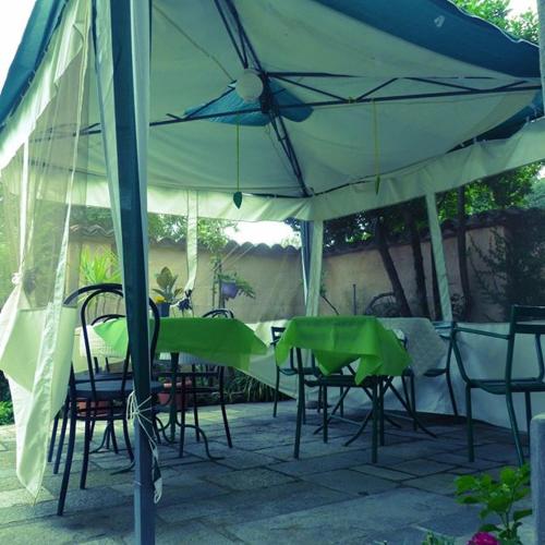 a group of tables and chairs under an umbrella at Casa Borio in Bioglio