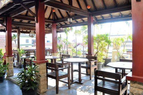 a restaurant with tables and chairs in a pavilion at Hotel Mataram 2 Malioboro in Yogyakarta