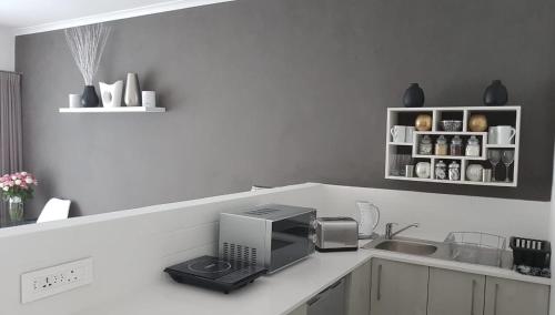 a kitchen with a sink and a microwave on a counter at HORIZON BAY - Camps Bay in Cape Town