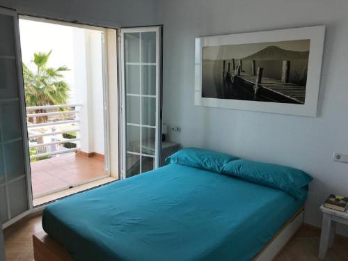 1 dormitorio con cama azul y ventana grande en Casa Elena, en Cuevas del Almanzora