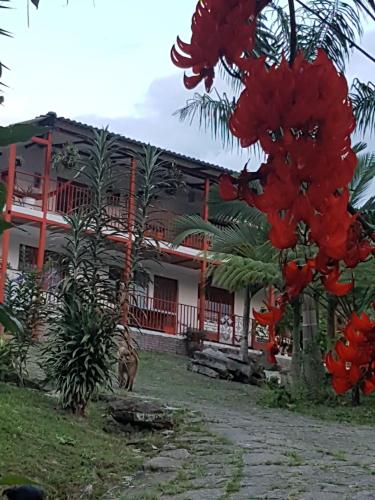 a house with red flowers in front of it at Finca Jardín del Agua in Sasaima