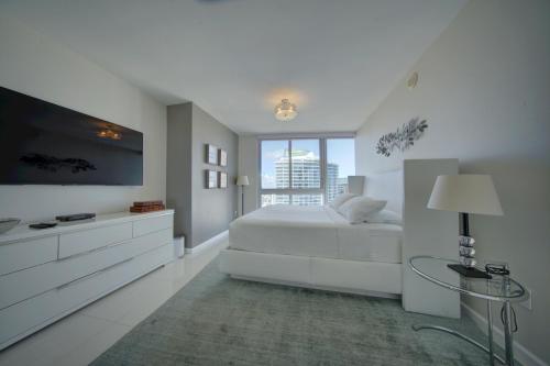 ein weißes Schlafzimmer mit einem Bett und einem Flachbild-TV in der Unterkunft Miami Luxury Condo in Brickell! Free SPA and Gym in Miami