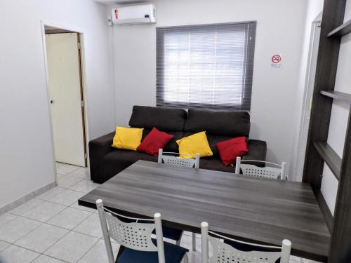 a living room with a table and a couch at Flat Pé de Mamão in Campinas
