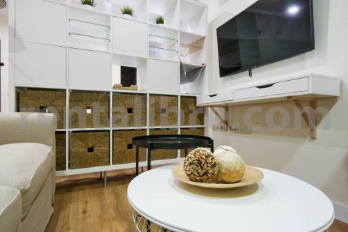 un salon avec une table et une télévision dans l'établissement Loft24SANLUCAR, à Sanlúcar de Barrameda