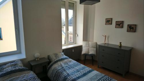 1 dormitorio con 2 camas y ventana en Le Gite du Relais, en Masevaux