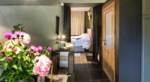 a hallway with a room with a bed and flowers at De Zevende Hemel in Merendree