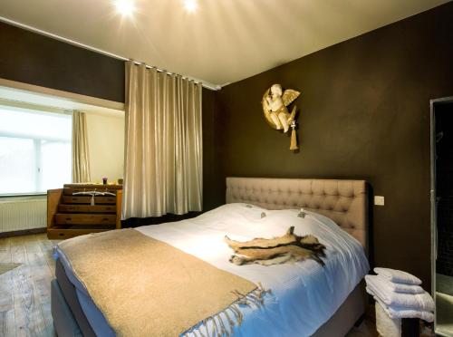 a bedroom with a bed with a cat on it at De Zevende Hemel in Merendree