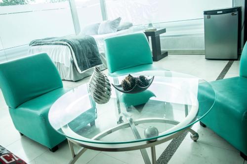 a living room with two green chairs and a glass table at Giakor Suites - Gran Jardín in León