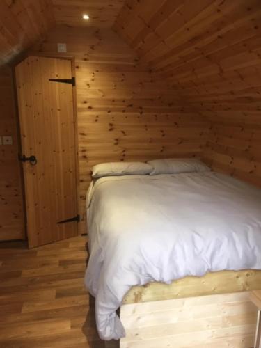 ein Schlafzimmer mit einem Bett in einer Holzwand in der Unterkunft Lodge in Yeovil