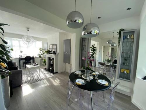 Luxury 5* Home with Secret Garden and Free Parking في ليفربول: غرفة معيشة مع طاولة سوداء وكراسي