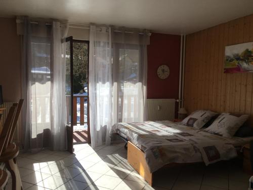 een slaapkamer met een bed en een glazen schuifdeur bij Au pieds des 3 vallées in Brides-les-Bains