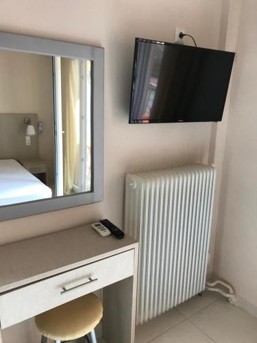 Zimmer mit einem Schreibtisch, einem Spiegel und einem Heizkörper in der Unterkunft Eleni Kandilari Rooms in Kókkinon Nerón