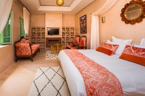 RIAD AZRUR في مراكش: غرفة نوم مع سرير وغرفة معيشة