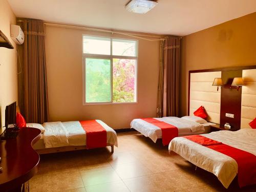 Ένα ή περισσότερα κρεβάτια σε δωμάτιο στο Xishuangbanna Aerial Garden Daijiangnan Mekong River South Business Hotel
