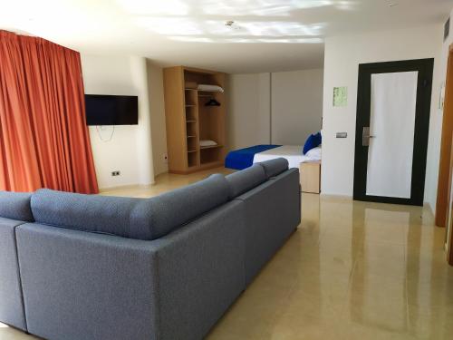 a living room with a couch and a bed at Hotel Pocillos Playa, solo Adultos in Puerto del Carmen