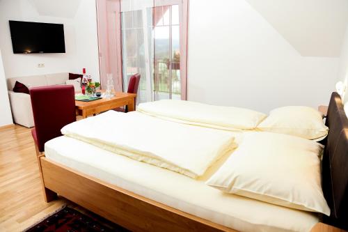 1 dormitorio con cama, mesa y ventana en Weingut Zirngast en Leutschach