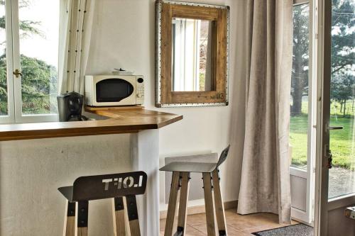 uma cozinha com um balcão, 2 bancos e um micro-ondas em Gite rural Herbignac - La Roche Bernard em Herbignac