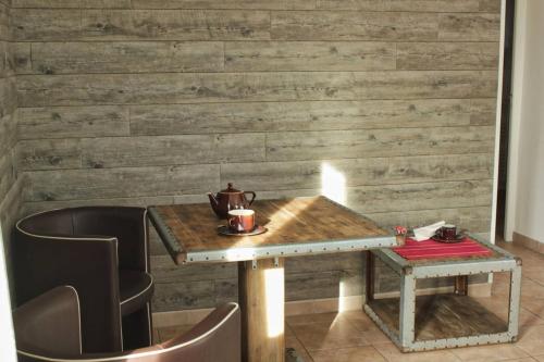 uma mesa com duas cadeiras e uma parede de madeira em Gite rural Herbignac - La Roche Bernard em Herbignac