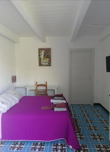 um quarto com uma cama roxa num quarto em Il giardino di Don Peppino em Oristano