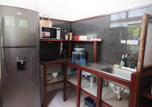 a kitchen with a stainless steel refrigerator and a sink at Villa 3 - High End Studio Apartment with kitchen, Playa Chiquita in Cocles