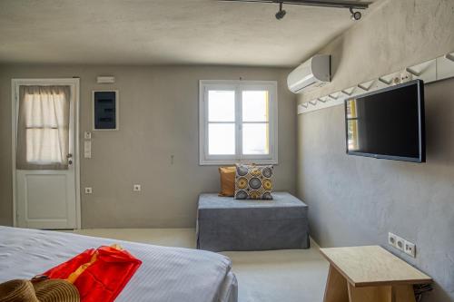 a bedroom with a bed and a television on the wall at SifnosLiving A3 in Vathi