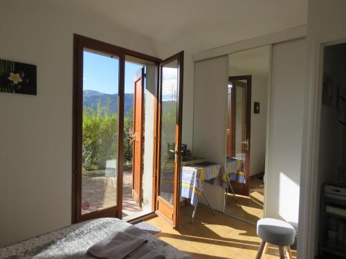 a bedroom with a door open to a balcony at Mon ecrin de nature rez de jardin in Seyne