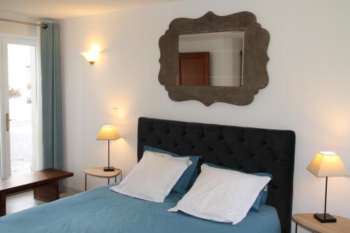 a bedroom with a bed with a mirror on the wall at La Ferme de la Place in Bouvines